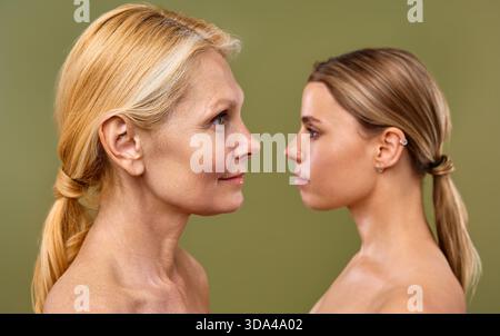 Femmes jeunes et matures avec une peau du visage saine et claire debout sur fond d'olive. Cosmétologie, soins de la peau et soins spa. Chirurgie plastique Banque D'Images