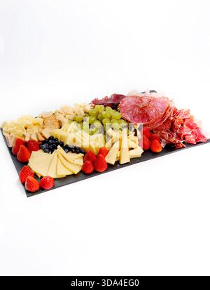 Panneau de charcuterie présentant un assortiment de fromages, charcuteries, fruits et craquelins Banque D'Images