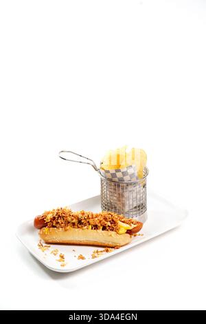 Hot dog classique garni d'oignons frits croustillants servis avec un côté de chips de pommes de terre Banque D'Images