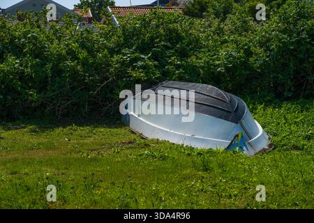 Bateau renversé reposant sur l'herbe verte Banque D'Images