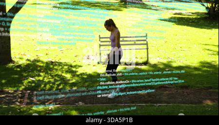 Marchant femme violet réservoir noir leggings vérifiant la cellule dans le parc ensoleillé, recouvrement de code bourgeons, espace de copie Banque D'Images