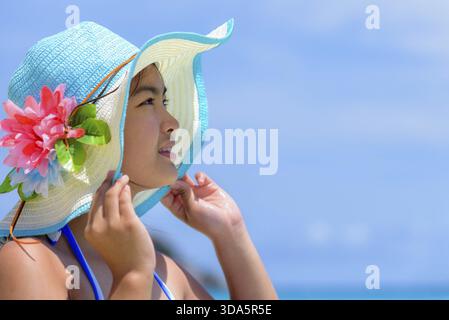Visage jeune femme portant un chapeau de protection solaire est heureuse de voir la belle nature de la mer et de la plage sous le ciel d'été à Koh Miang Island à Mu Ko si Banque D'Images