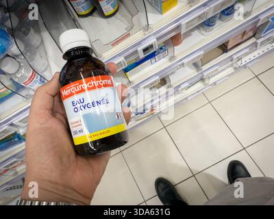 HYÈRES, FRANCE - 27 SEPTEMBRE 2025 : une bouteille d'eau oxygénée Mercurochrome, peroxyde d'hydrogène, tenue dans une allée de supermarché à Hyères. C'est un F commun Banque D'Images