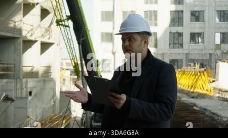 Ingénieur et contremaître discutant des plans sur un chantier de construction Banque D'Images