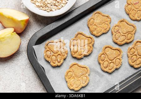 Biscuits d'aliments pour animaux en forme de patte sur une plaque à pâtisserie, prêts à servir Banque D'Images