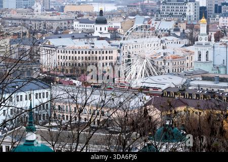 Surplombant une ville animée, une roue géante se dresse au milieu des bâtiments historiques. Kiev, Ukraine. 8 décembre 2025. Banque D'Images
