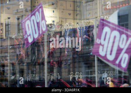 Des affiches de solde brillantes annoncent d'énormes rabais sur divers vêtements élégants en vue. Podil, Kiev, Ukraine. 8 décembre 2025. Banque D'Images