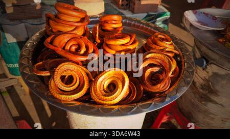 Ceci est une image en gros plan de nombreux aliments enroulés et serpents disposés sur un plateau métallique. Banque D'Images