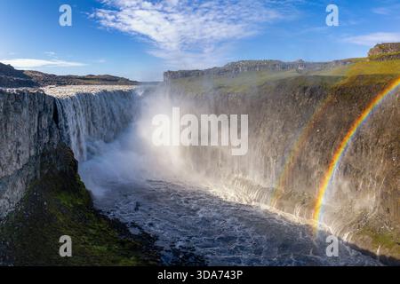 Une vue sur la majestueuse cascade de Dettifoss dans le nord-est de l'Islande avec un double arc-en-ciel par une belle journée d'été Banque D'Images