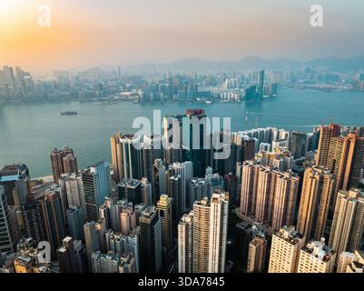Vue aérienne de gratte-ciels étincelants perçant le ciel, reflétant le paysage urbain animé et le port scintillant, l'île de Hong Kong, l'île de Hong Kong, Banque D'Images