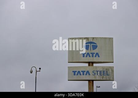 Un signe de logo altéré et sale de la société Tata Steel debout contre un ciel gris nuageux avec une caméra de sécurité visible sur le côté gauche. IJmuiden Banque D'Images