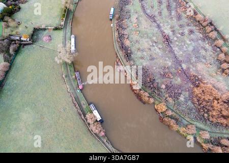 Vue aérienne des péniches amarrées le long de la Tamise sinueuse, contrastant avec les champs et arbres verdoyants givrés, Sonning, Oxfordshire, United Kin Banque D'Images