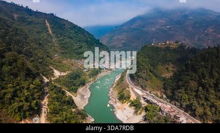 Vue aérienne de la rivière serpentine Trishuli serpentant à travers le terrain accidenté, embrassé par des montagnes verdoyantes et la sinueuse Prithvi Highway, Pok Banque D'Images