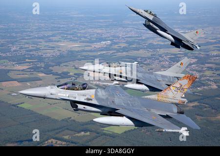 Trois F-16 Fighting Falcons de l'armée de l'air belge du Tiger Squadron, immatriculés FA-104, FA-106 et FA-116, volent en formation rapprochée lors d'une mission photo air-air au Sanicole Air Show de 2019 en Belgique. Les avions maintiennent un espacement serré et un alignement stable, soulignant leur précision opérationnelle. Banque D'Images