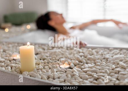 Expérience spa relaxante avec chandelles et pierres apaisantes dans un cadre paisible Banque D'Images