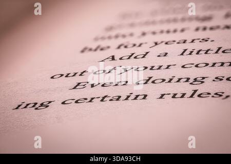 Macro gros plan d'un texte imprimé sur une page de livre ouvert avec une faible profondeur de champ. Banque D'Images