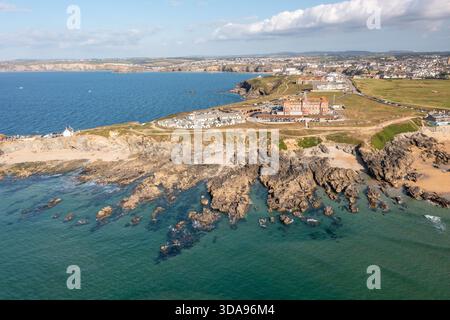 Vue aérienne de la côte rocheuse rencontre la mer turquoise, avec le Headland Hotel se démarquant du paysage, Newquay, Angleterre, Royaume-Uni. Banque D'Images