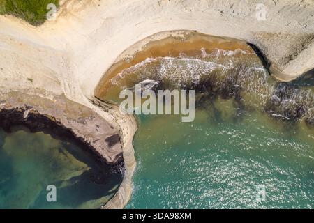 Vue aérienne de la côte spectaculaire du Cap Drastis où les falaises blanches rencontrent la mer Ionienne turquoise, Cap Drastis, Corfou, Grèce. Banque D'Images
