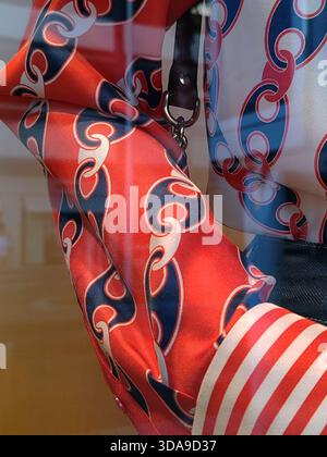 Cannes, France - 7 juin 2025 : gros plan d'une manche de chemisier en soie Gucci à imprimé chaîne rouge, marine et blanche avec manchette rayée exposée dans un vent de boutique Banque D'Images