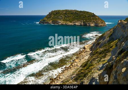 Isla del Portitxol île et vagues se brisant sur le rivage des falaises de la plage de Portichol (Jávea, Marina Alta, Alicante, mer Méditerranée, Espagne) Banque D'Images