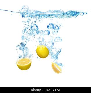 Citrons tombant dans l'eau sur fond blanc Banque D'Images