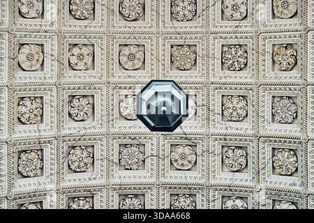 Plafond à caissons complexes orné de rosettes florales détaillées dans des panneaux carrés encastrés, capturés depuis une perspective centrée vers le haut avec un l naturel doux Banque D'Images
