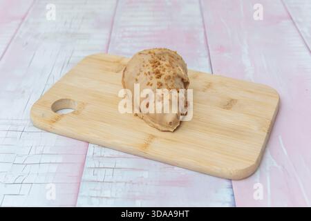 Gros plan d'un croissant fraîchement cuit montrant son intérieur en spirale avec de grandes poches d'air irrégulières, à côté d'un couteau à beurre Banque D'Images