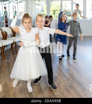 Tween filles ad garçons dansant la danse partenaire lente pendant l'événement festif Banque D'Images