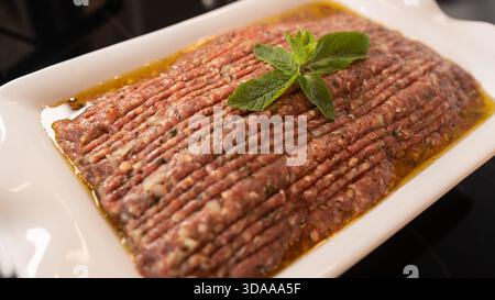 Kibbeh nayeh libanais traditionnel – viande crue finement hachée mélangée à du boulgour et des épices. Servi frais sur une assiette avec de l'huile d'olive. Authentique moyen-Orient Banque D'Images