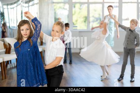 Tween filles ad garçons dansant la danse partenaire lente pendant l'événement festif Banque D'Images