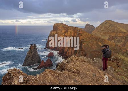 Photographe prenant des photos sur les falaises, les arcs-en-ciel sur la mer, la péninsule volcanique, Ponta de Sao Lourenco, Ponta de Sao Lourenco, la côte rocheuse, Punta de S. Banque D'Images