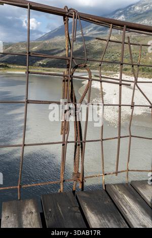 Vieux pont suspendu avec des planches de bois au-dessus de la rivière Vjosa, Tepelene, comté de Gjirokaster, Albanie Banque D'Images