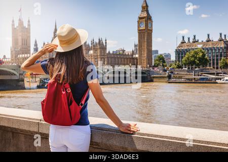 Une femme touriste regarde la tour de l'horloge Big Ben à Londres, en Angleterre, pendant une journée d'été ensoleillée Banque D'Images