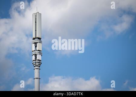 Un mât de téléphone mobile 5G contre un ciel bleu. Banque D'Images