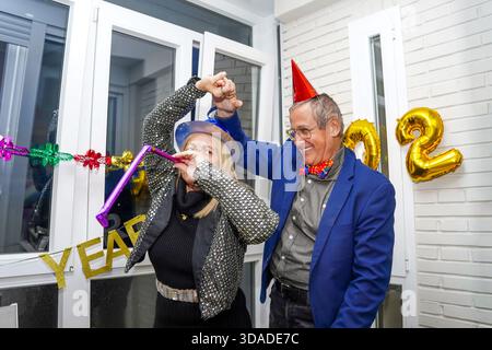 Couple senior festif s'amusant la veille du nouvel an Banque D'Images