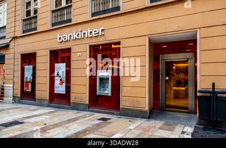 Bankinter extérieur de banque, ATM, affiches de prêt. Malaga, Espagne, rue du centre-ville historique. Façade traditionnelle, chaussée mouillée, Banque D'Images