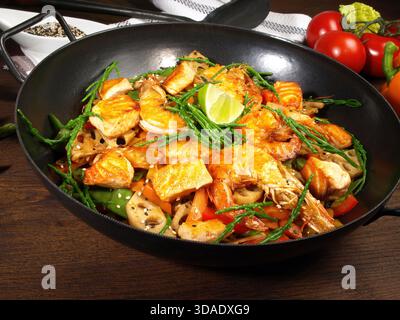 Wok asiatique au saumon, crevettes et légumes Banque D'Images