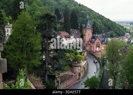 Pittoresque petit château luxuriant sur la colline de Heidelberg entoure de charmants bâtiments historiques route sinueuse menant à la tour de briques ornées. Lumière de verdure fraîche Banque D'Images