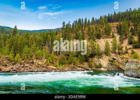 Vue panoramique à couper le souffle sur la rivière Kootenay couleur émeraude qui coule gracieusement à travers un paysage majestueux de crêtes de montagnes boisées Banque D'Images