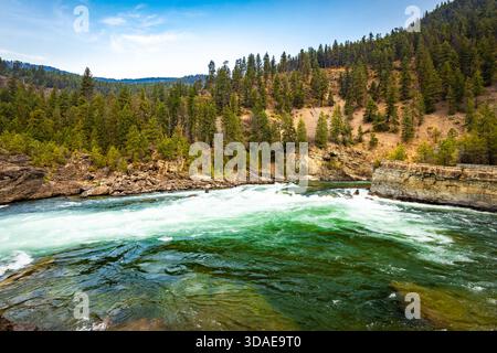 Vue panoramique à couper le souffle sur la rivière Kootenay couleur émeraude qui coule gracieusement à travers un paysage majestueux de crêtes de montagnes boisées Banque D'Images