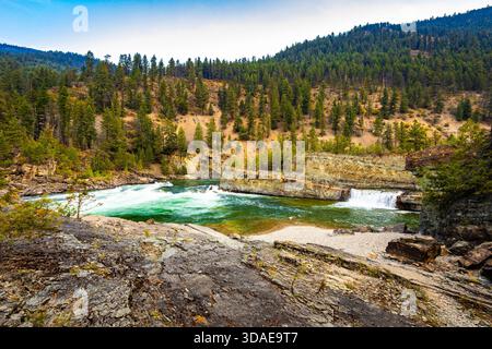 Vue panoramique à couper le souffle sur la rivière Kootenay couleur émeraude qui coule gracieusement à travers un paysage majestueux de crêtes de montagnes boisées Banque D'Images