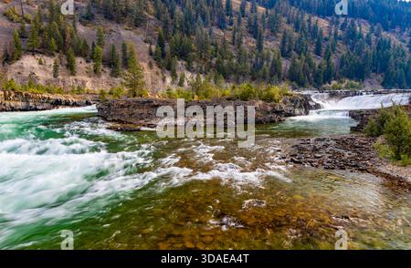 Vue panoramique à couper le souffle sur la rivière Kootenay couleur émeraude qui coule gracieusement à travers un paysage majestueux de crêtes de montagnes boisées Banque D'Images