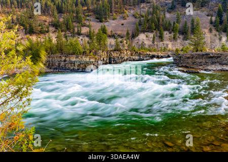 Vue panoramique à couper le souffle sur la rivière Kootenay couleur émeraude qui coule gracieusement à travers un paysage majestueux de crêtes de montagnes boisées Banque D'Images