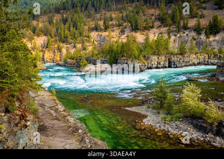 Vue panoramique à couper le souffle sur la rivière Kootenay couleur émeraude qui coule gracieusement à travers un paysage majestueux de crêtes de montagnes boisées Banque D'Images