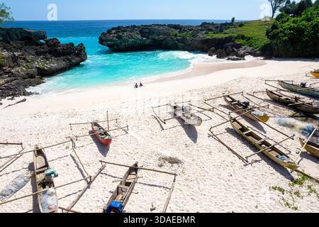 Belle plage de sable mandorak sur l'île de sumba en indonésie, plage de sable blanc, eau turquoise, falaises, crique de mer, bateaux de pêche traditionnels en bois Banque D'Images