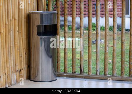 Gros plan d'une poubelle/poubelle en acier inoxydable à double fonction avec cendrier intégré sur le dessus, placée sur un balcon. Convient pour intérieur ou extérieur Banque D'Images