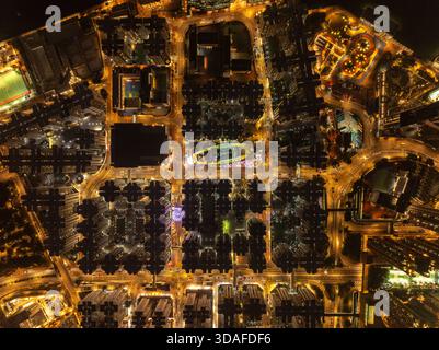 Vue aérienne des lumières de la ville illuminant le paysage urbain, avec la forme distinctive de l'hippodrome de Happy Valley visible, Hong Kong, Hong Ko Banque D'Images