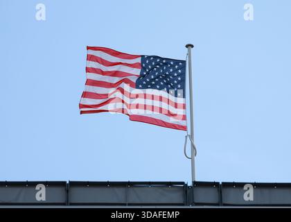 Étoiles et rayures drapeau américain contre ciel bleu pâle. Banque D'Images
