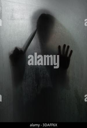 L'ombre de l'horreur meurtrier tenant un couteau tranchant derrière le verre dépoli dans la salle de bains Banque D'Images