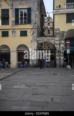 Gênes, Italie - 14 NOVEMBRE 2025 - place et entrée d'une ruelle sous un arc avec un panneau éteint dessus menant à une église Banque D'Images